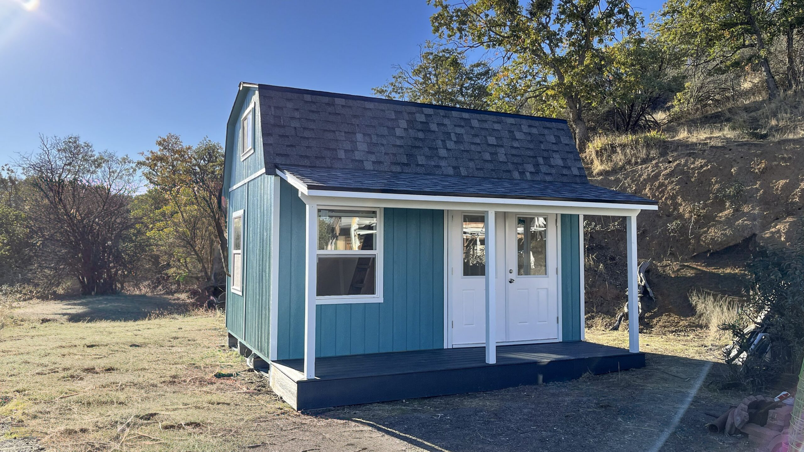 Blue barn-style building with covered porch and double entry doors